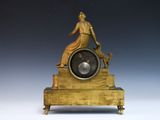 a statue of a woman sitting on top of a clock