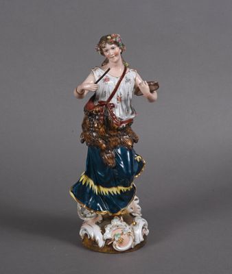 an antique figurine of a woman holding a dog