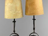 two lamps on a stand with a lamp shade on top of them
