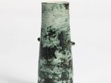 a green vase that is sitting on a white surface