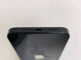the back of a black cell phone sitting on top of a white table