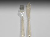 deux fourchettes et un couteau sur une table blanche