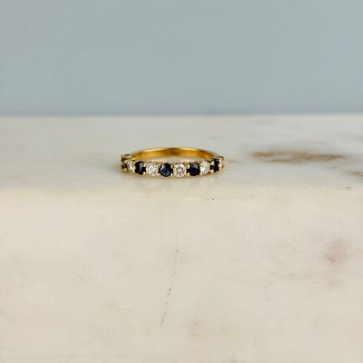 une image représentant une bague en or sertie de diamants noirs et blancs