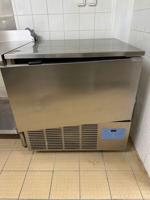 un congélateur en acier inoxydable dans un coin de la salle de bains