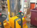 a yellow forklift in a warehouse with boxes in the background