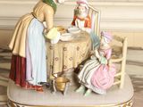 a figurine of a woman and two children sitting at a table