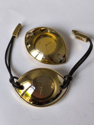 paire de lunettes plaquées laiton, avec un cordon noir sur un fond blanc
