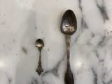 deux cuillères et un repose-cuillère posés sur une table en marbre
