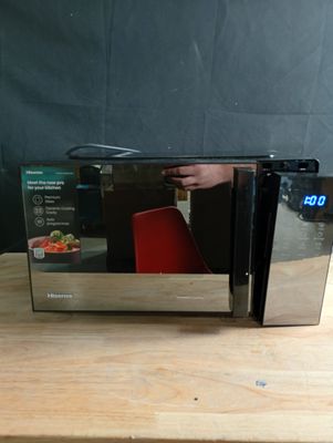 un micro-ondes posé sur une table à côté d'une chaise rouge