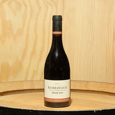 a bottle of wine sitting on top of a barrel