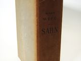 an old book sitting on top of a table on a white surface