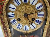 a gold clock with blue and white decorations on it