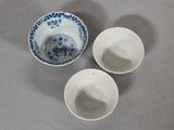 three white bowls with blue designs on them sitting on a table