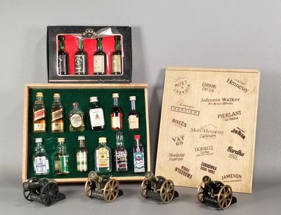 des bouteilles d'alcool dans une caisse en bois et un cadre photo posés sur une table