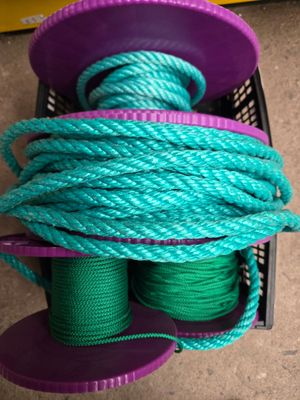 un tas de cordes vertes et violettes dans un panier posé par terre