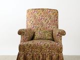 an upholstered chair in a room with a white wall behind it