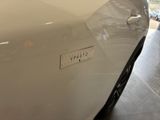 a close up of a white car with a sticker on it