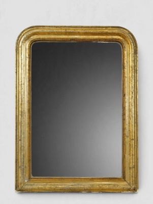 un miroir à cadre doré accroché à un mur blanc sur fond noir