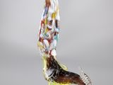 une photo d'une sculpture en verre représentant un oiseau posée sur un socle
