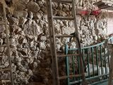 Plusieurs échelles sont appuyées contre un mur de pierre dans une pièce.