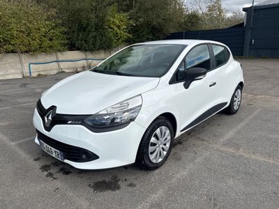 La voiture blanche est garée sur le parking devant un immeuble.