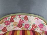 a pink and orange striped chair with a floral pattern on it