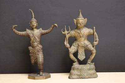 two bronze statues of a man and a woman on a rock