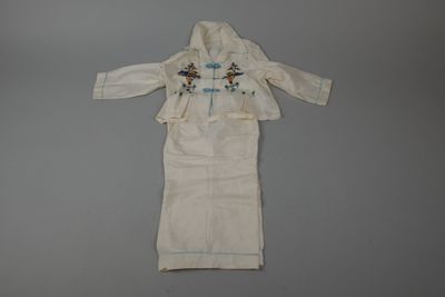 une image représentant une robe blanche ornée de motifs bleus et verts