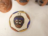 three clay heads of people are sitting on a white surface
