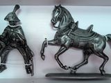 two figurines of a man riding a horse and a man riding a horse