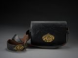 porte-monnaie en cuir noir orné d'un lion doré sur le devant et muni d'une lanière en cuir