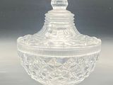 clear glass lidded jar with a decorative design on the top