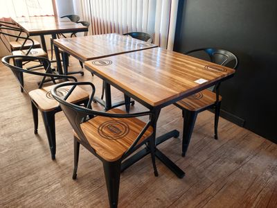 des tables et des chaises dans une pièce avec une fenêtre en arrière-plan