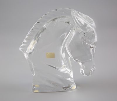 sculpture en verre transparent représentant une tête de cheval sur fond blanc