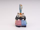 a figurine of a group of people on top of a bell
