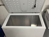 a small white chest freezer sitting in a bathroom