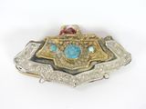 a silver and gold belt buckle with a turquoise stone in the center