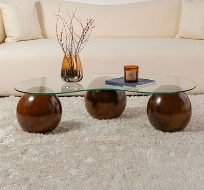 une table basse en verre sur laquelle sont posées deux boules en bois