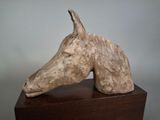 a sculpture of a horse ' s head on a wooden stand