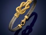 a gold and silver bracelet with a knot on it