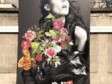 a picture of a woman holding a bunch of flowers on the side of a building