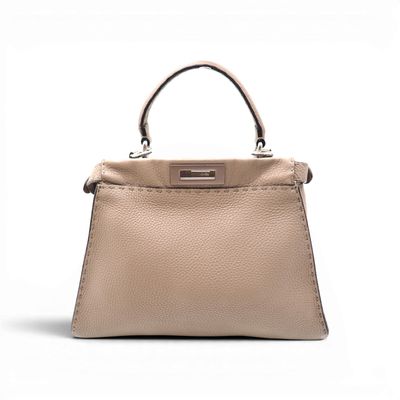 a beige leather handbag on a white background