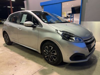 Une voiture argentée est garée dans un garage à côté d'un immeuble