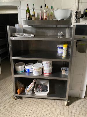 une cuisine équipée d'étagères en inox et où l'on trouve beaucoup de provisions
