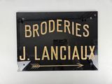 une enseigne sur laquelle est inscrit « broderies j lanciaux »