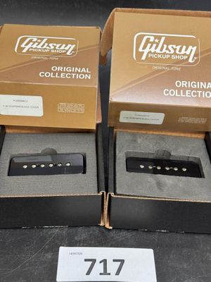 Deux boîtes de micros Gibson sont posées sur une table, avec une étiquette de prix