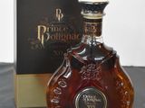 the bottle of brandy is next to the box on the table
