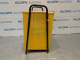 a yellow cart sitting on top of a floor next to a wall