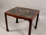 une image représentant une petite table en bois ornée d'un motif noir et or