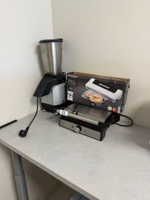 une cafetière et un mixeur posés sur une table